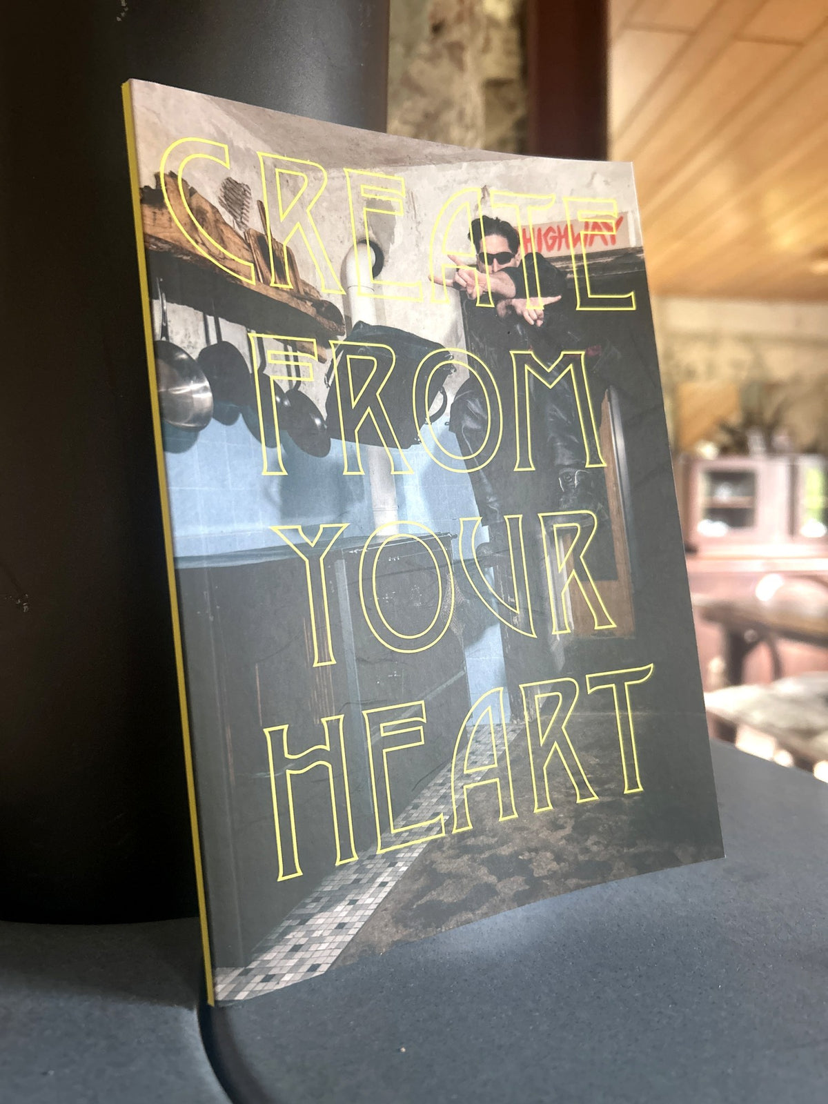 Das signierte Buch „Create from your Heart“ von HESSEDOGG steht aufrecht an einer dunklen Säule